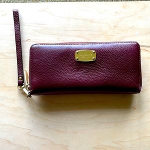 Michael Kors women’s zip up pebble leather burgundy/maroon wallet.